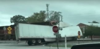 Watch a train plow through a semi truck stuck on the tracks